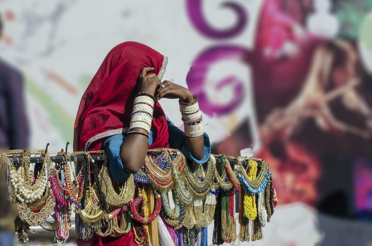 Woman in traditional Indian saree dresses selling ornamental necklaces