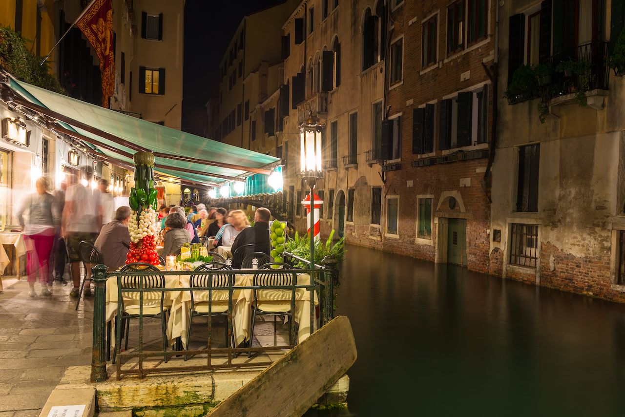 Night view of canal and restaurant in Venice, Italy